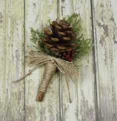 a pine cone is tied to a piece of wood