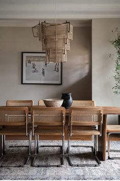 a dining room table with chairs and a vase