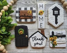 decorated cookies are arranged on a table with words and flowers in the center, along with other cookie decorations