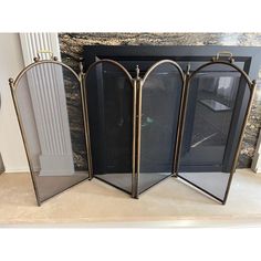 three metal fireplace screens sitting next to each other