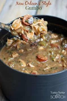 a spoon full of soup on top of a wooden table