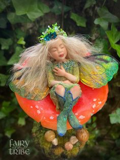 a fairy doll sitting on top of a mushroom