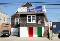 a small house with an italian flag painted on the side