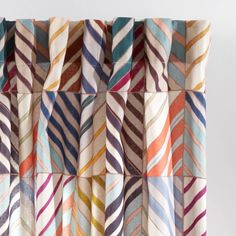 multicolored striped curtains hanging on a white wall