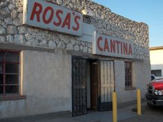 a red truck parked in front of a building with a sign that reads ross's cantinaa