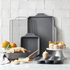 an assortment of baking supplies on a counter top with cupcakes and muffin tins