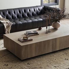 a living room with a black leather couch and coffee table