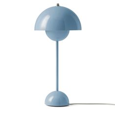 a blue table lamp sitting on top of a white floor next to a light bulb