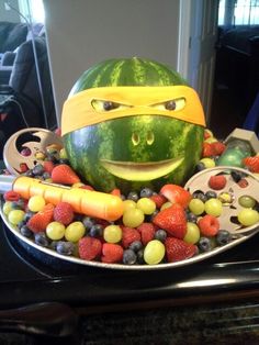 a watermelon with a helmet on top of it surrounded by fruits and vegetables