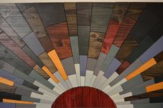 a wooden wall with many different colors and shapes on it's sides, including the sun