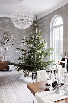 a living room with a christmas tree in the corner and other decorations on the table