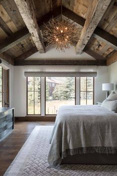 a large bed sitting under a wooden ceiling in a bedroom next to a sliding glass door