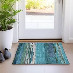 a pair of black shoes sitting on top of a door mat