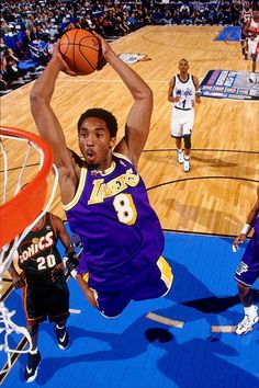 a basketball player dunks the ball in front of his opponent during a professional game