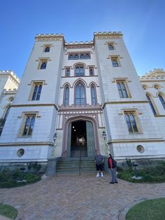 two people standing in front of a large building