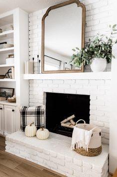 a living room with white brick fireplace and wooden floors