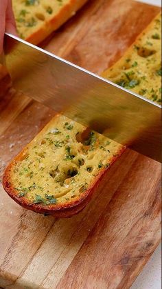 someone is using a large knife to cut bread