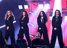 two women in black outfits standing on stage