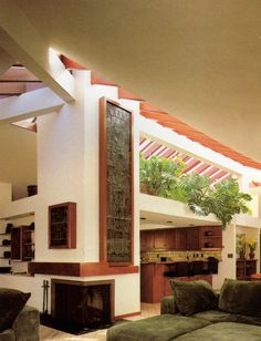 a living room filled with furniture and a fire place under a roof mounted planter