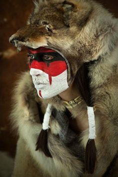 a person with a painted face and headdress