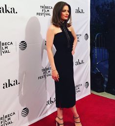 a woman in a black dress standing on a red carpet at the tribe film festival