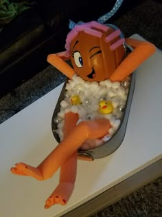 there is a doll in the bathtub with soap and rubber ducks on it's feet