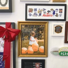 a group of framed pictures hanging on the side of a wall next to a red bow