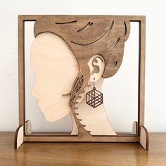 a wooden cutout of a woman's head with an earring