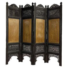 an intricately carved wooden screen with gold paint on the sides and bottom panel,