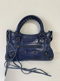 Balenciaga's 'Mini City' tote is one of the label's most iconic styles - instantly recognizable by its signature studs, buckled corners and whipstitched top handles. This blue version is crafted from light yet durable lambskin leather that will become even more supple over time. Carry it in-hand or cross-body. The metal plaque label is missing. No dust bag Balenciaga City Bag Mini, Balenciaga Mini City Bag, Balenciaga Mini City, Cross Over Bag, Balenciaga Tote, Mini City, Girly Bags, Sling Bags, Balenciaga Bag