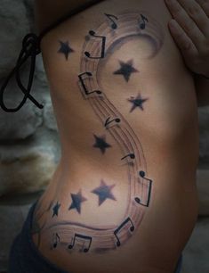 a woman's stomach with music notes and stars on it