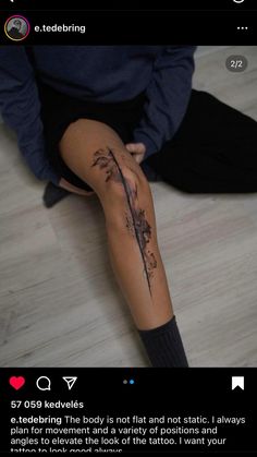 a person sitting on the floor with their legs crossed and tattoos on her leg,