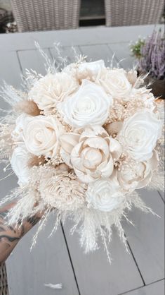 a bridal bouquet with white roses and feathers