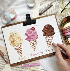 three ice cream cones on a clipboard next to some crayons and markers