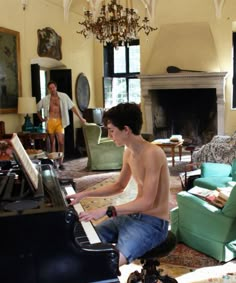 a young man sitting at a piano in a living room