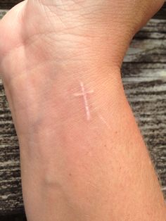 a person's arm with a cross on it