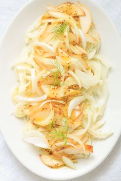 a white plate topped with onions and fennel