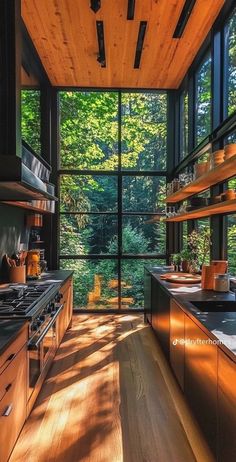 an open kitchen with wooden cabinets and floor to ceiling windows that overlook the trees outside