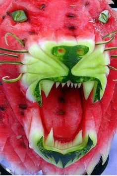 a watermelon carving of a cat's face with its mouth open