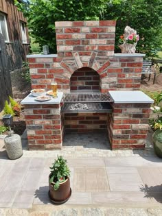 an outdoor brick pizza oven with potted plants