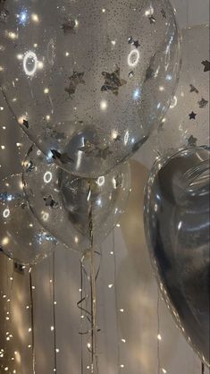 several clear balloons are floating in the air with stars and sparkles all around them