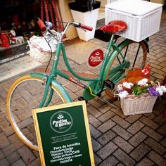 a green bicycle parked next to a sign