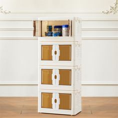 three drawers are stacked on top of each other in front of a white wall and wood floor