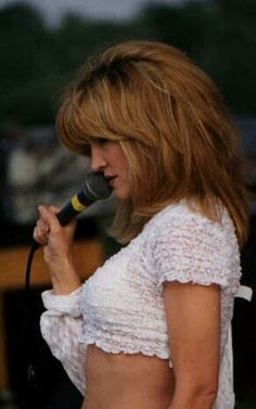 a woman singing into a microphone on stage