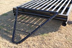 a metal bed frame sitting in the grass