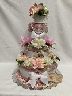 a multi tiered cake with pink and white flowers