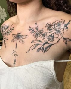 a woman wearing a white top with flowers and dragonflies on her chest