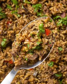 a spoon filled with rice and vegetables on top of a table