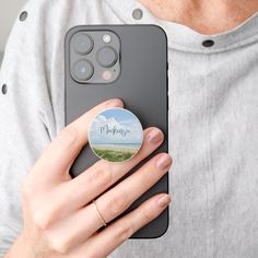 a person holding a cell phone with a sticker on it