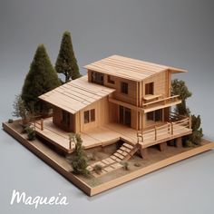 a wooden model of a house with stairs and trees